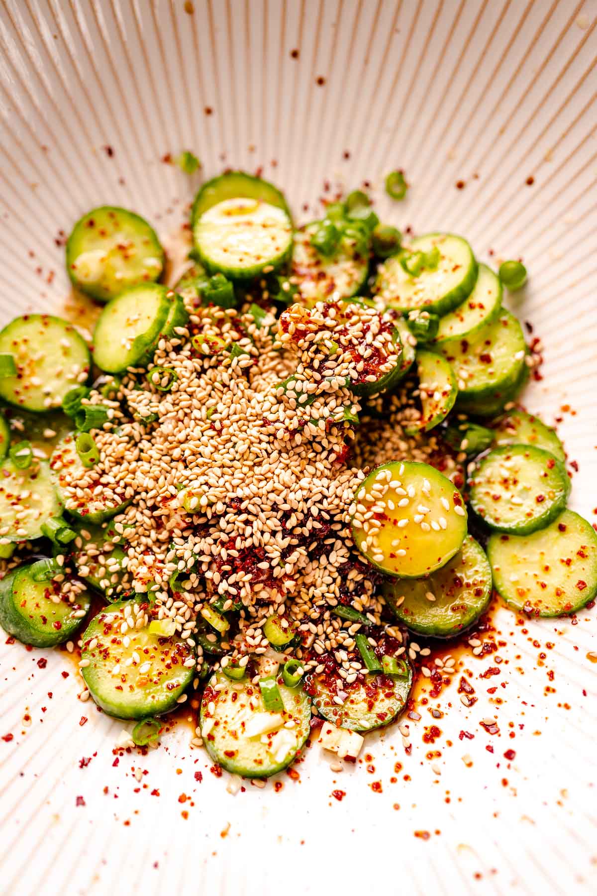 Slices of cucumber topped with sesame seeds.
