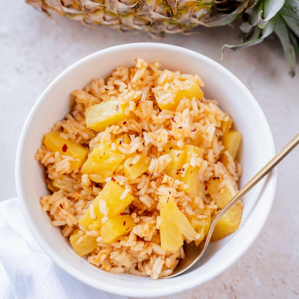 Pineapple and rice in a small ceramic white bowl.