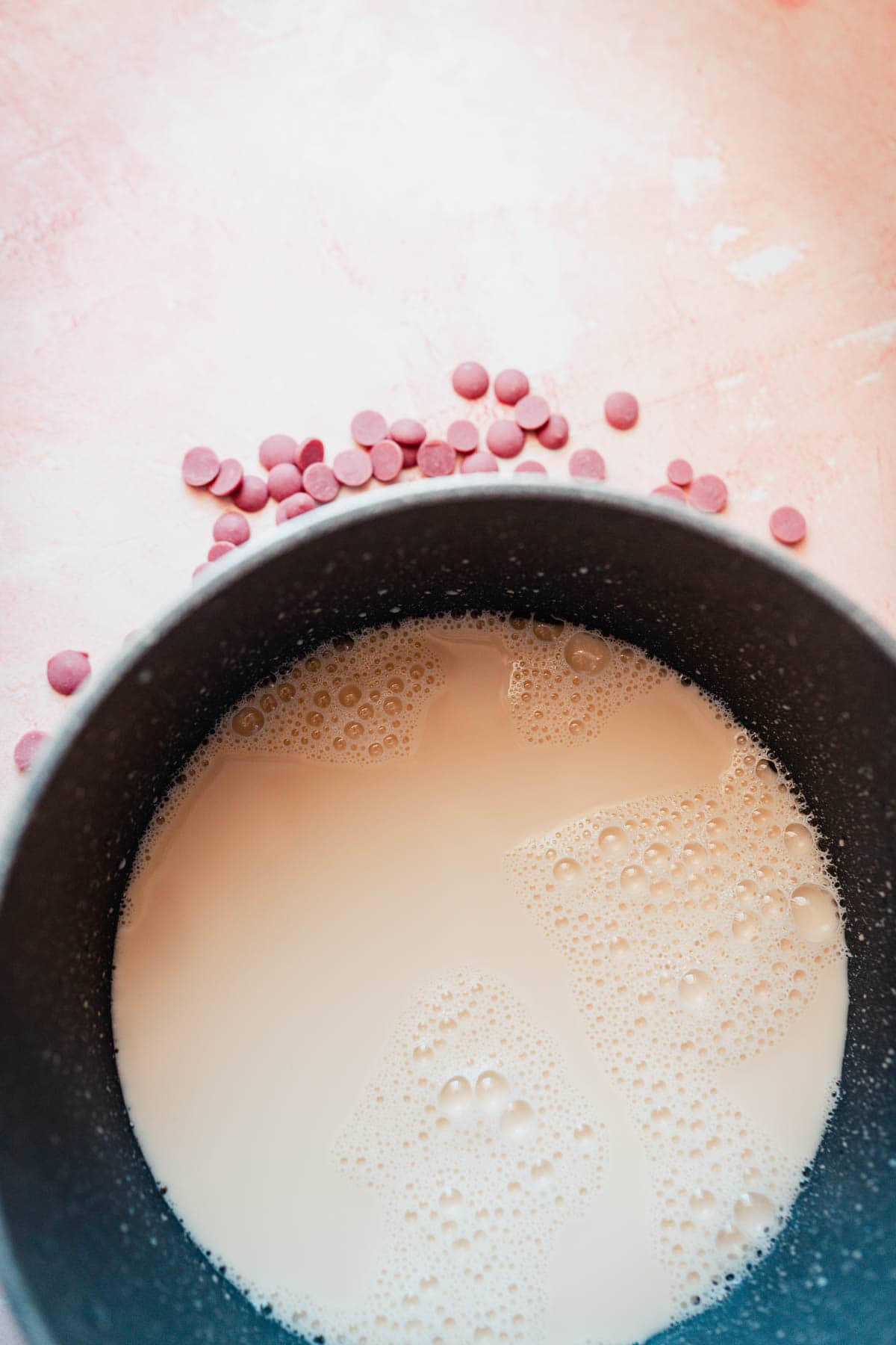 A dark gray saucepan filled with white milk.