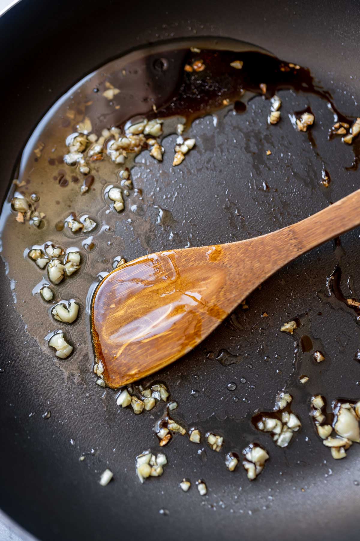 A skillet with oil and minced garlic.