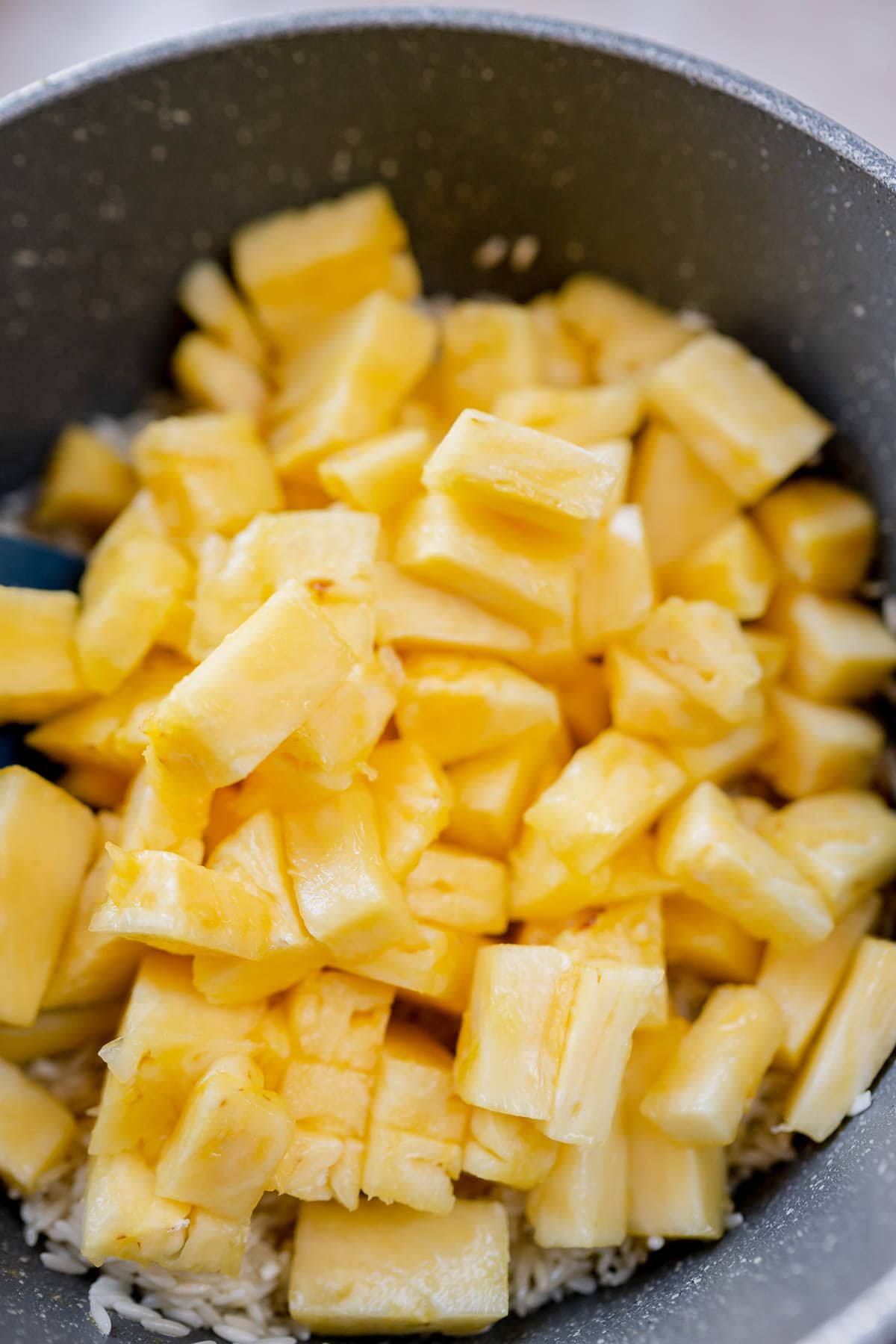A saucepan filled with pineapple chunks.