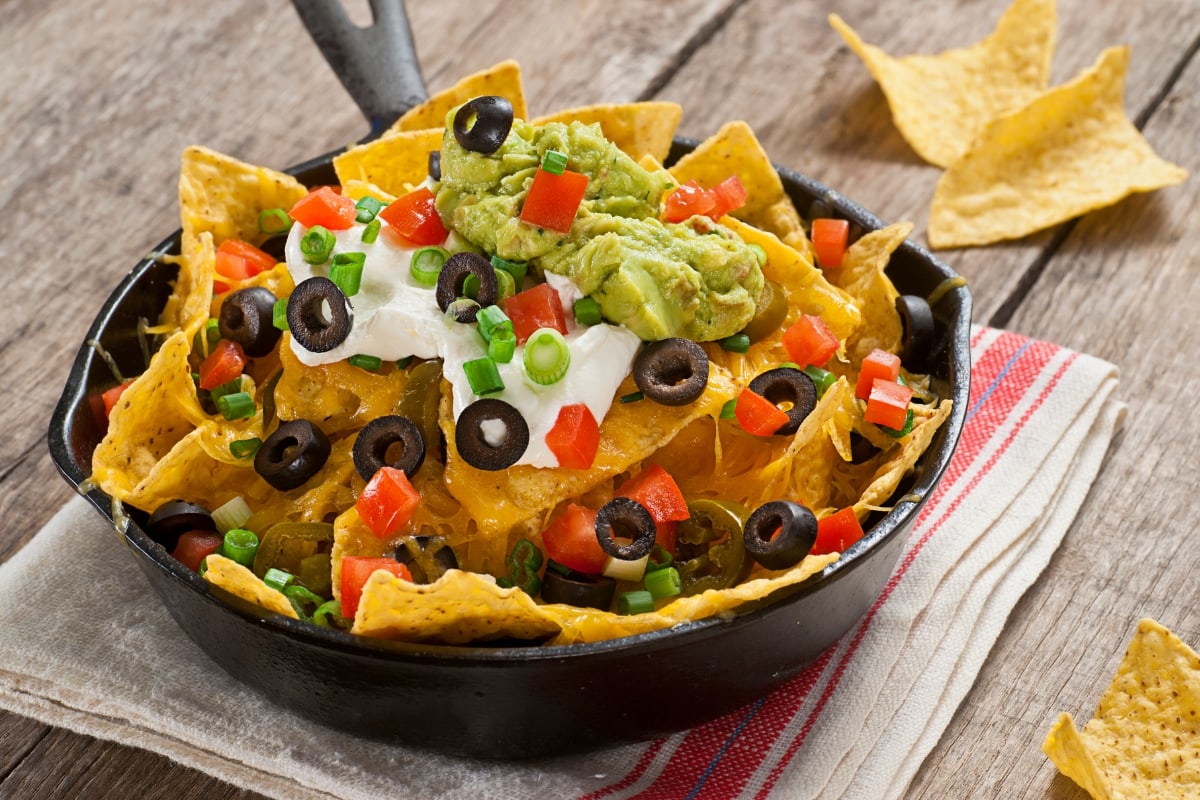 A cast iron skillet filled with vegetarian nachos.