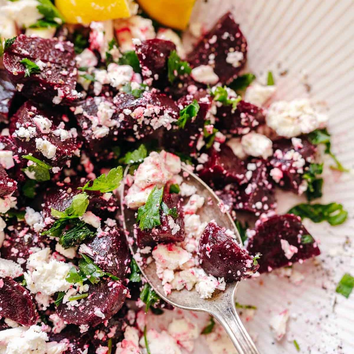 A silver spoon holds homemade beetroot feta salad.