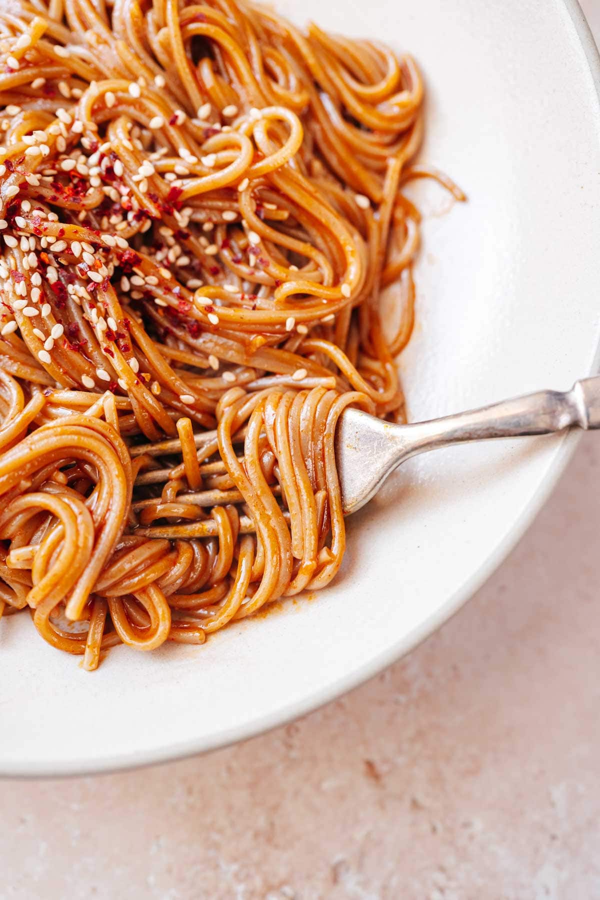 Close shot of noodles wrapped around a silver fork.