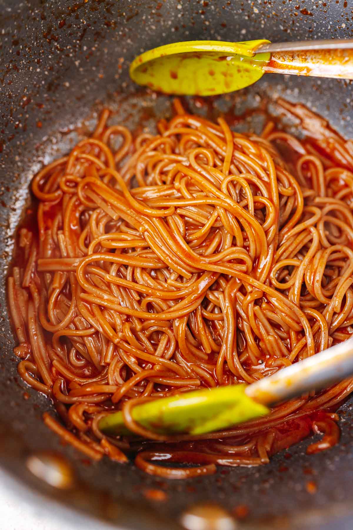 A large pot of noodles coated in a red sauce.