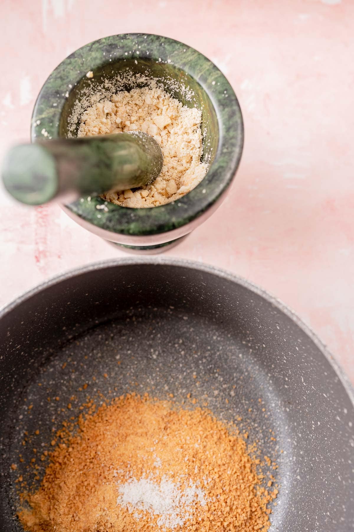 A mortar and pestle filled with crushed nuts.