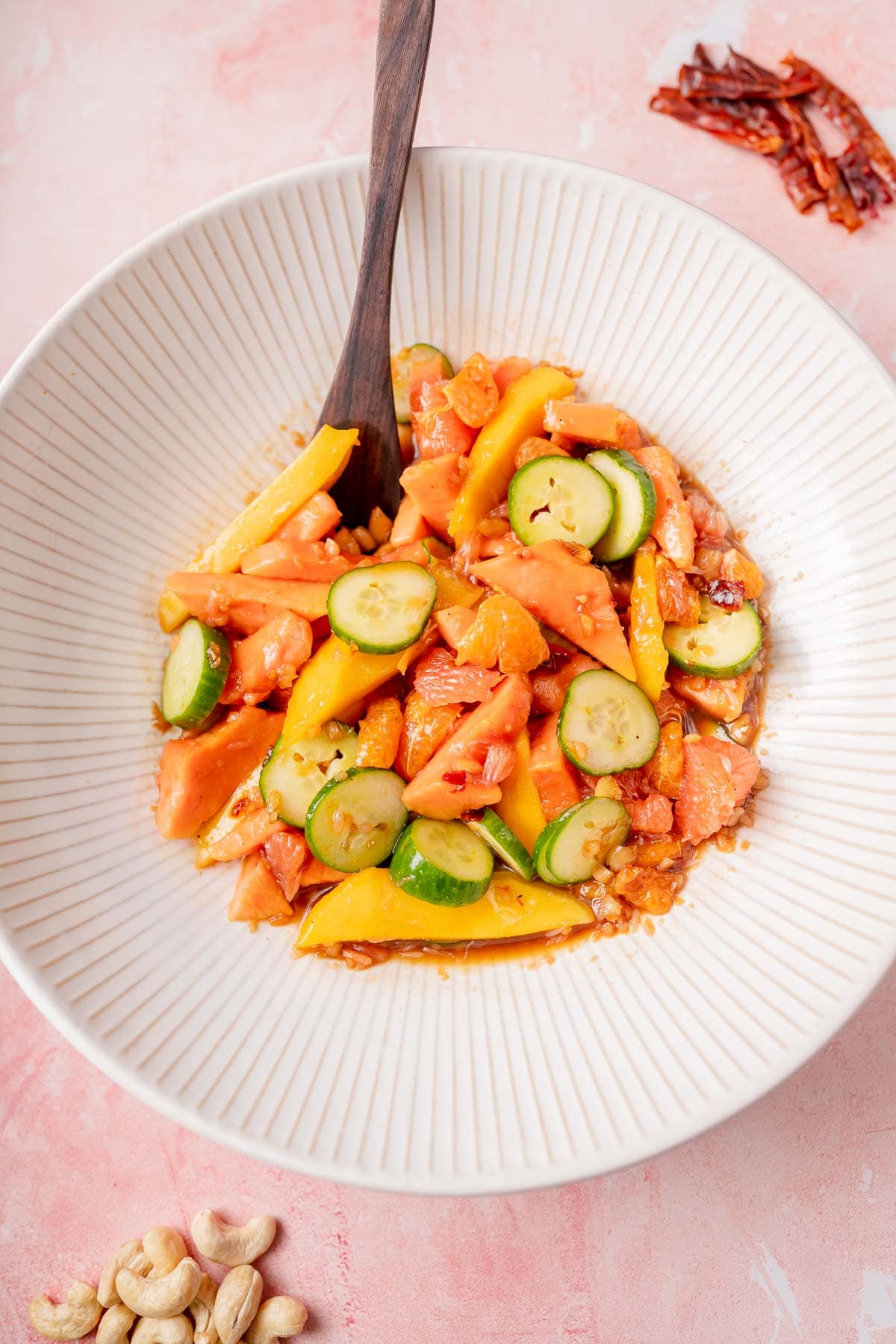 A bright fruit salad in a large white salad bowl.