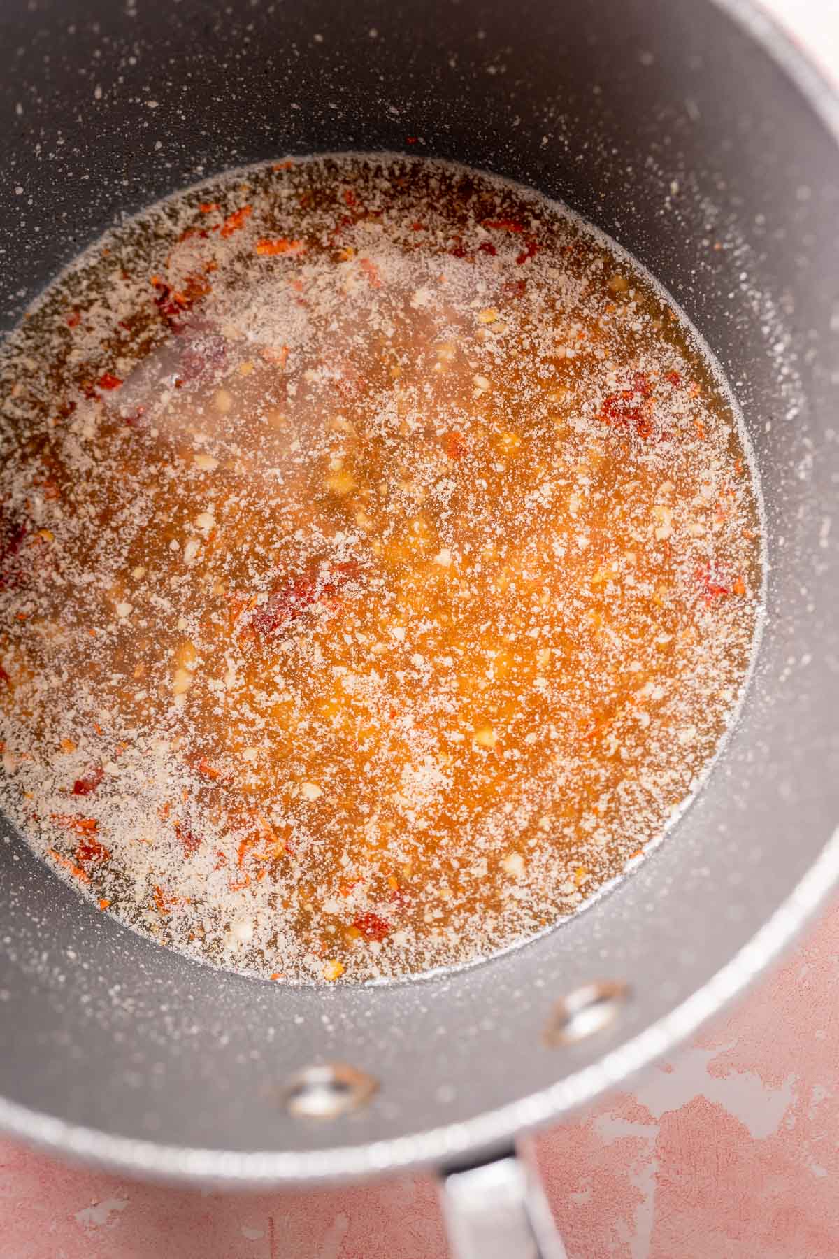 A saucepan filled with a simmering liquid.