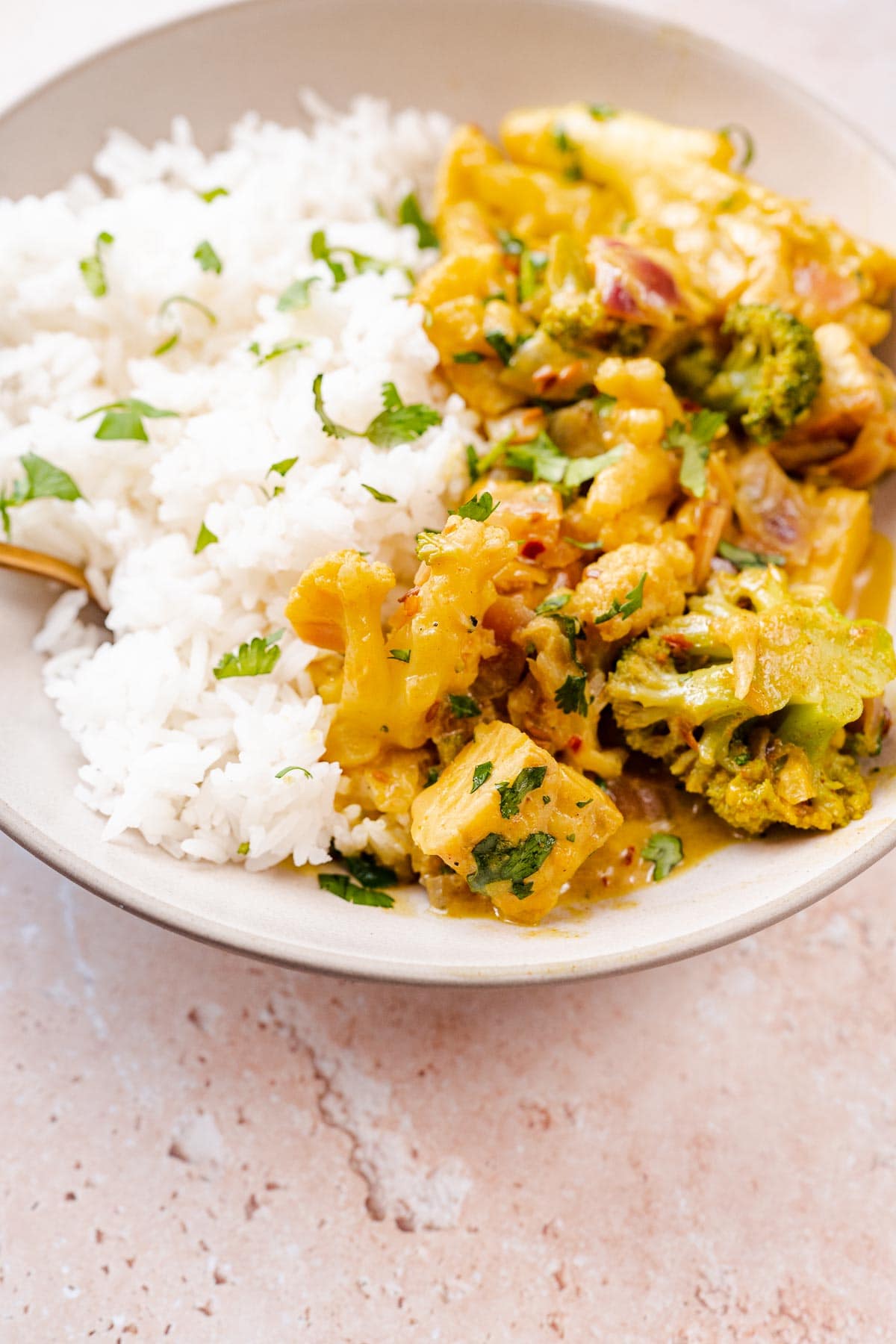 A large ceramic bowl of yellow curry and rice.