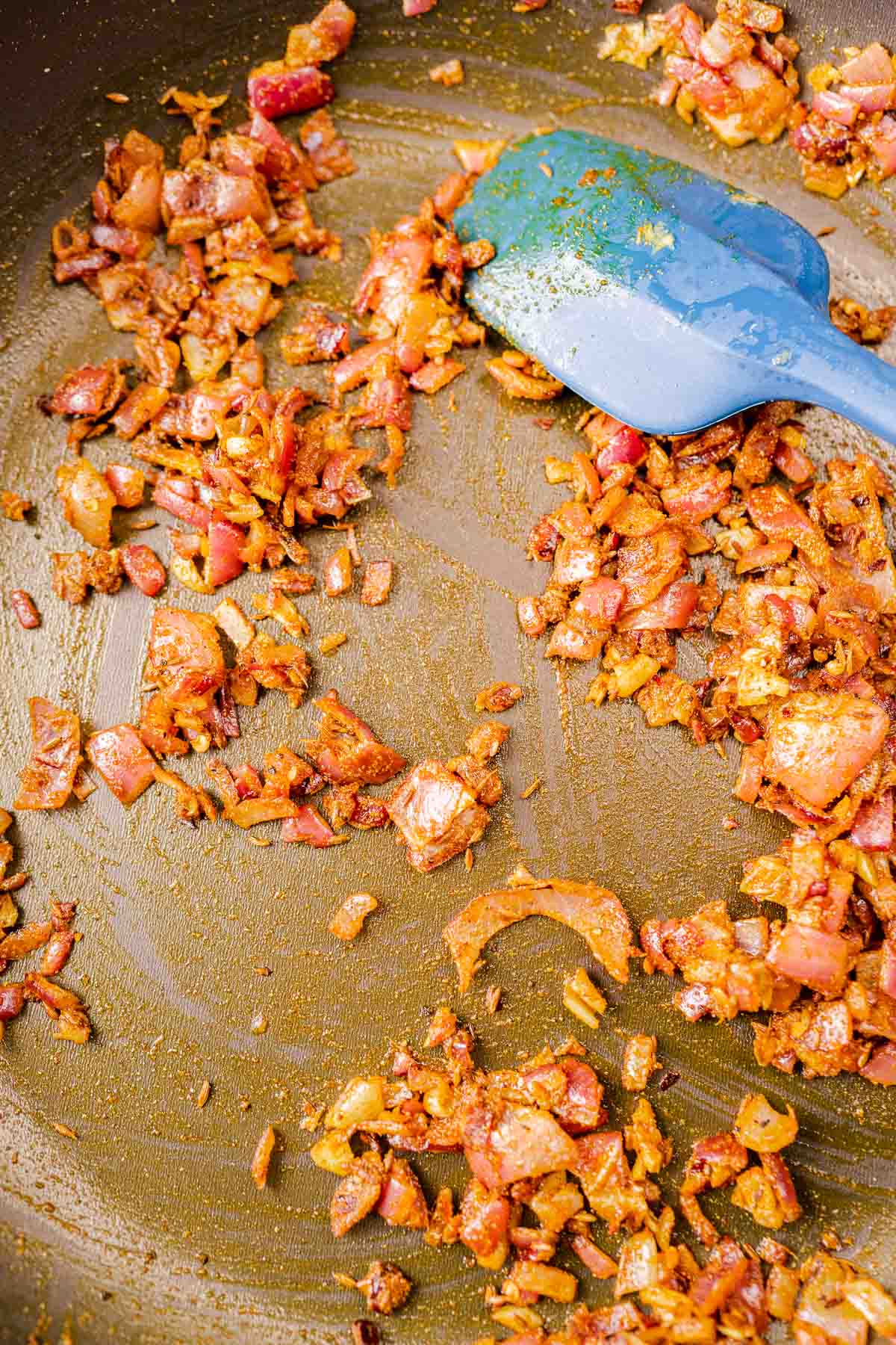 A skillet with spices and onions.