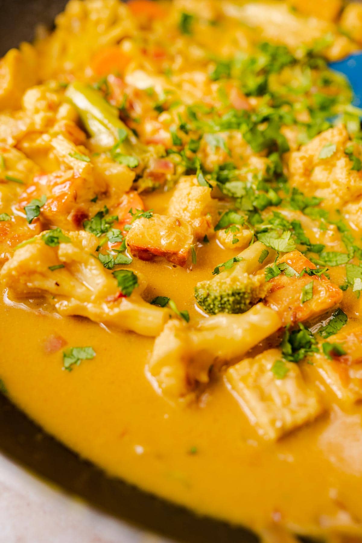 A skillet filled with a vibrant yellow vegetarian curry.