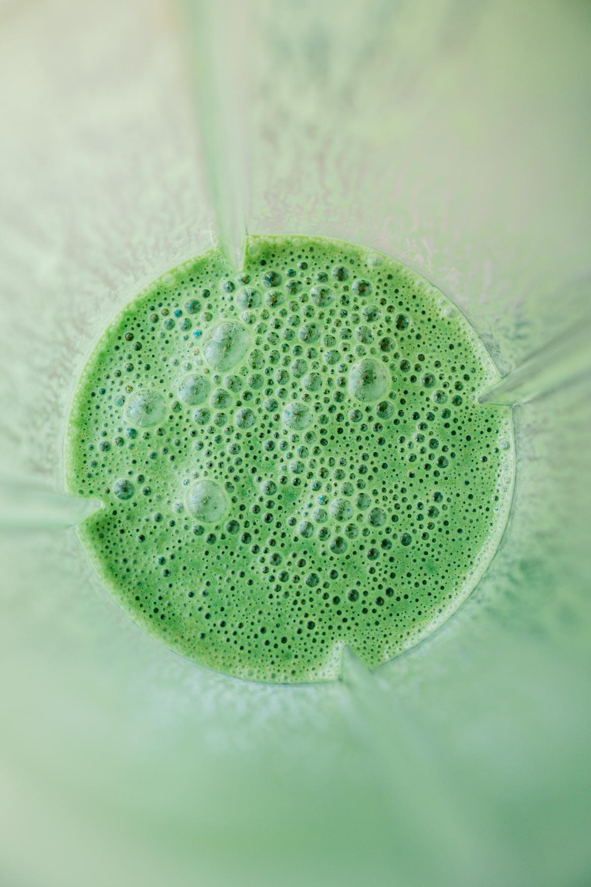 A blender filled with a green liquid.