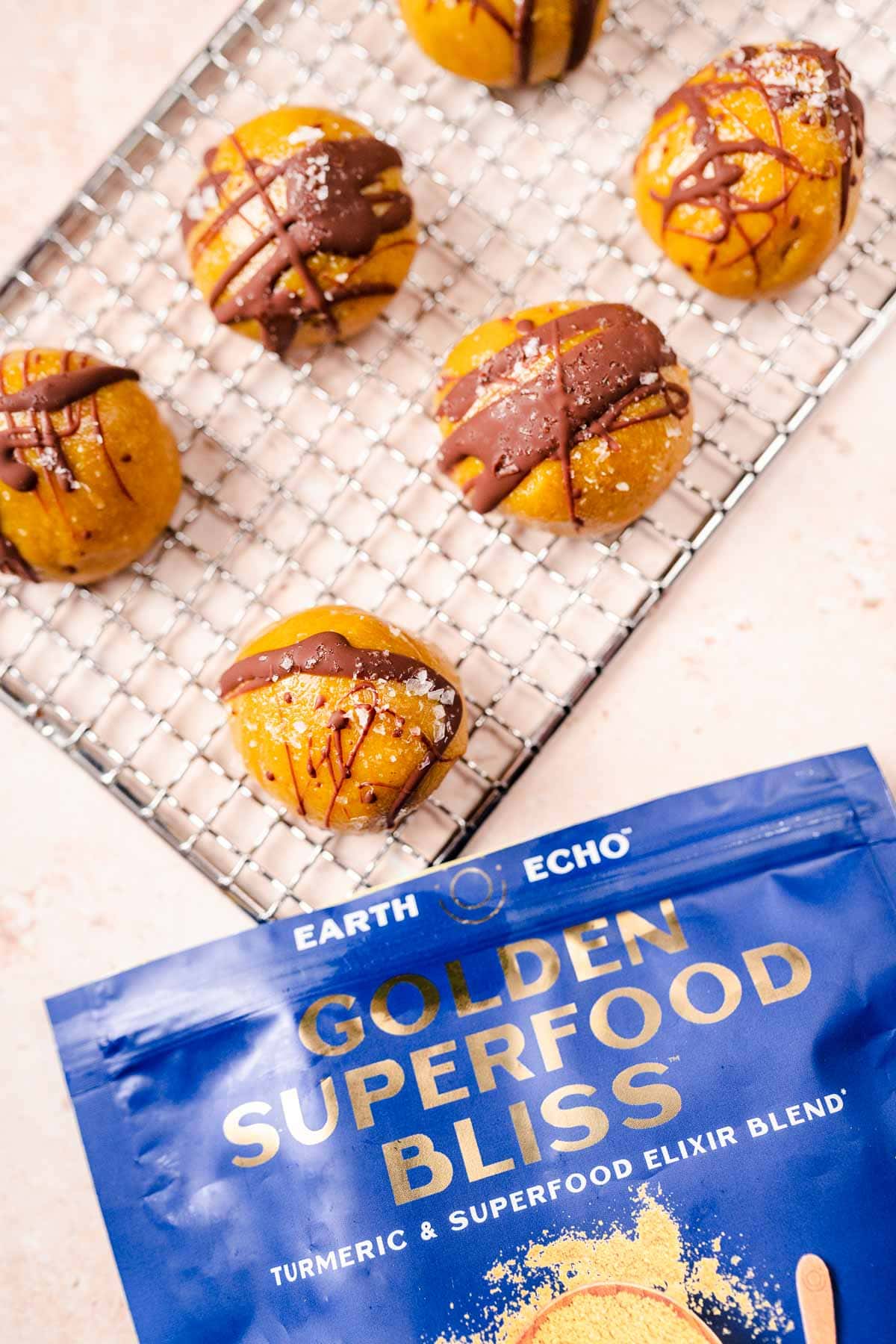 Top view of golden milk bites and a blue Earth Echo Golden Superfood Bliss bag.