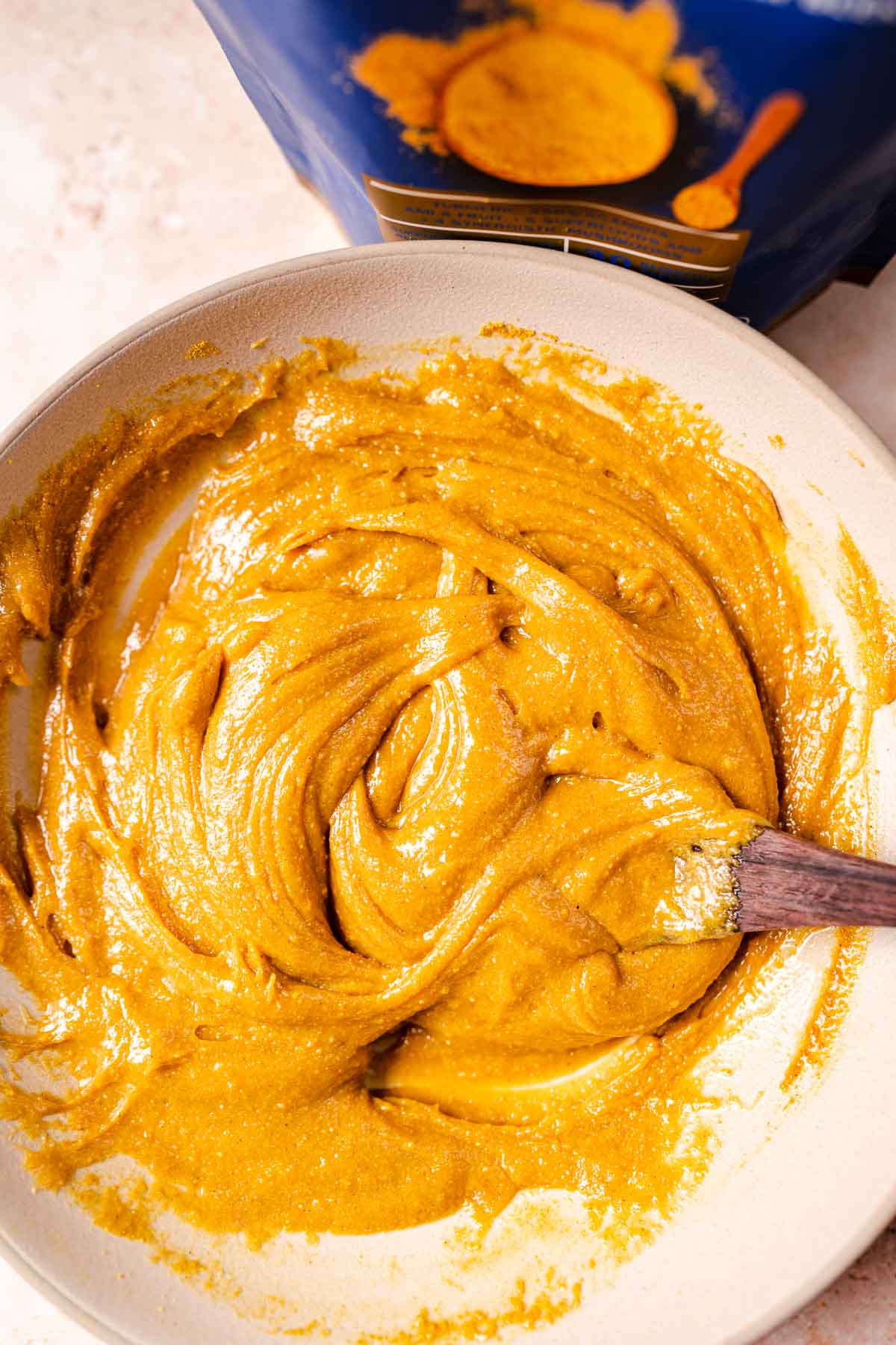 A bowl filled with a yellow batter.