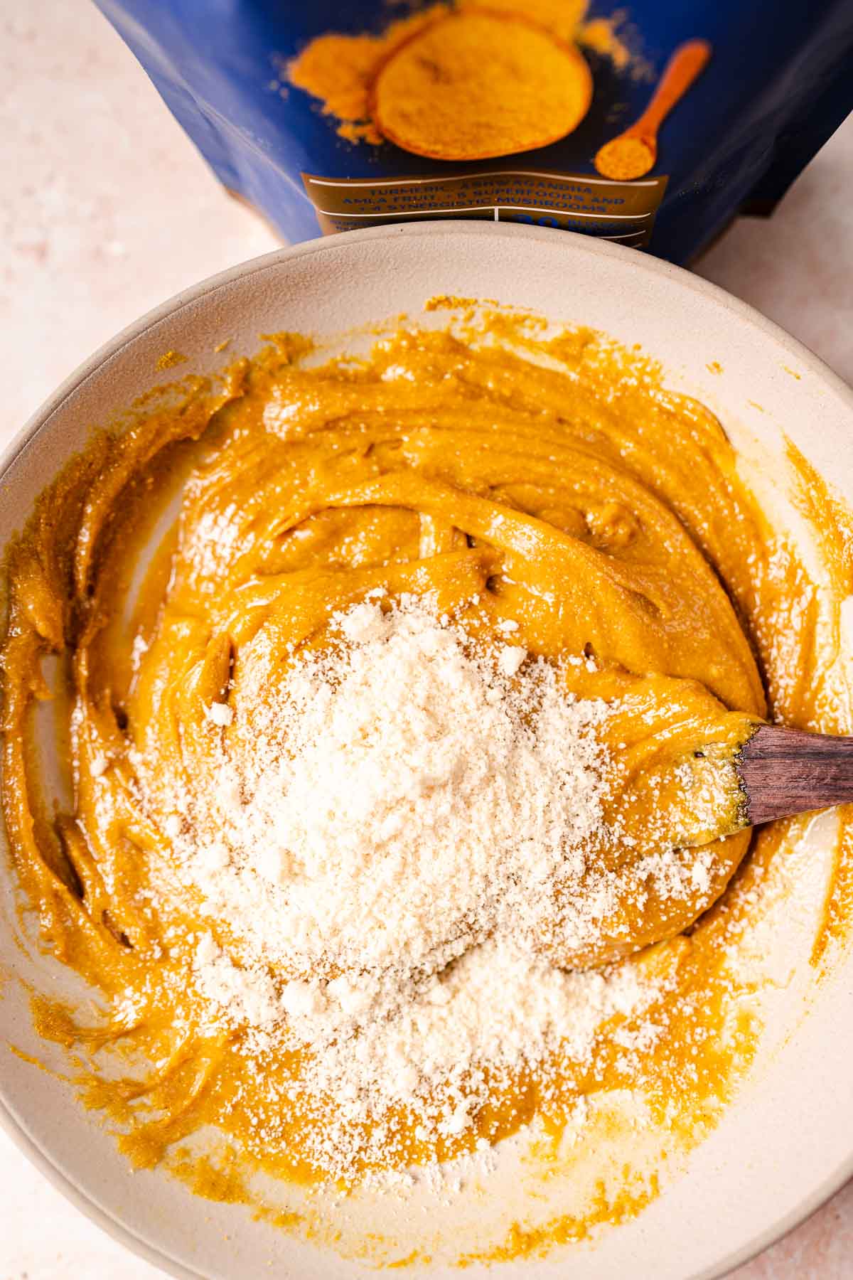 A bowl filled with yellow batter and white almond flour.