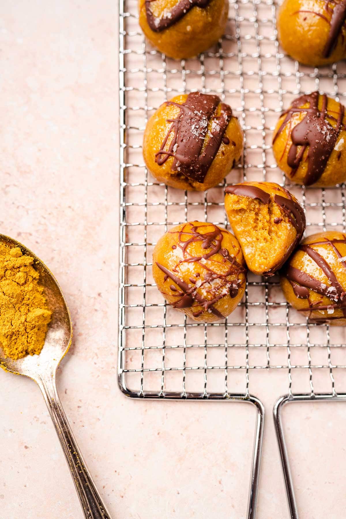 Close shot of golden milk bites resting on a silver grate.