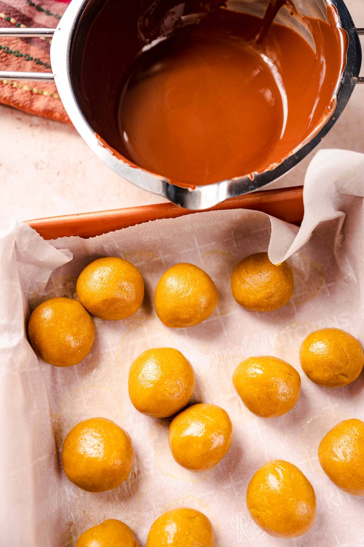 Yellow balls resting in a baking pan.