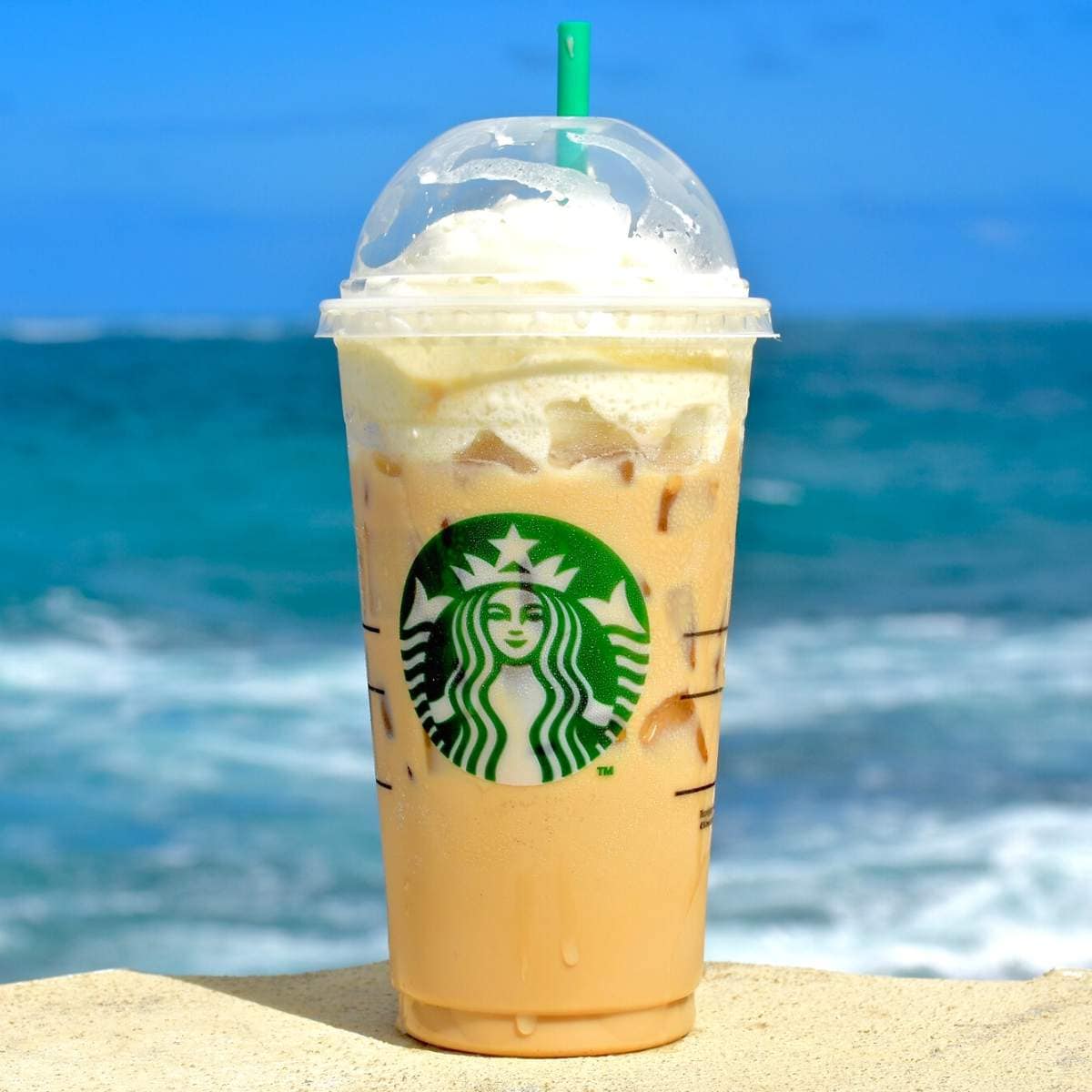 A tall Starbucks cup filled with an iced drink.