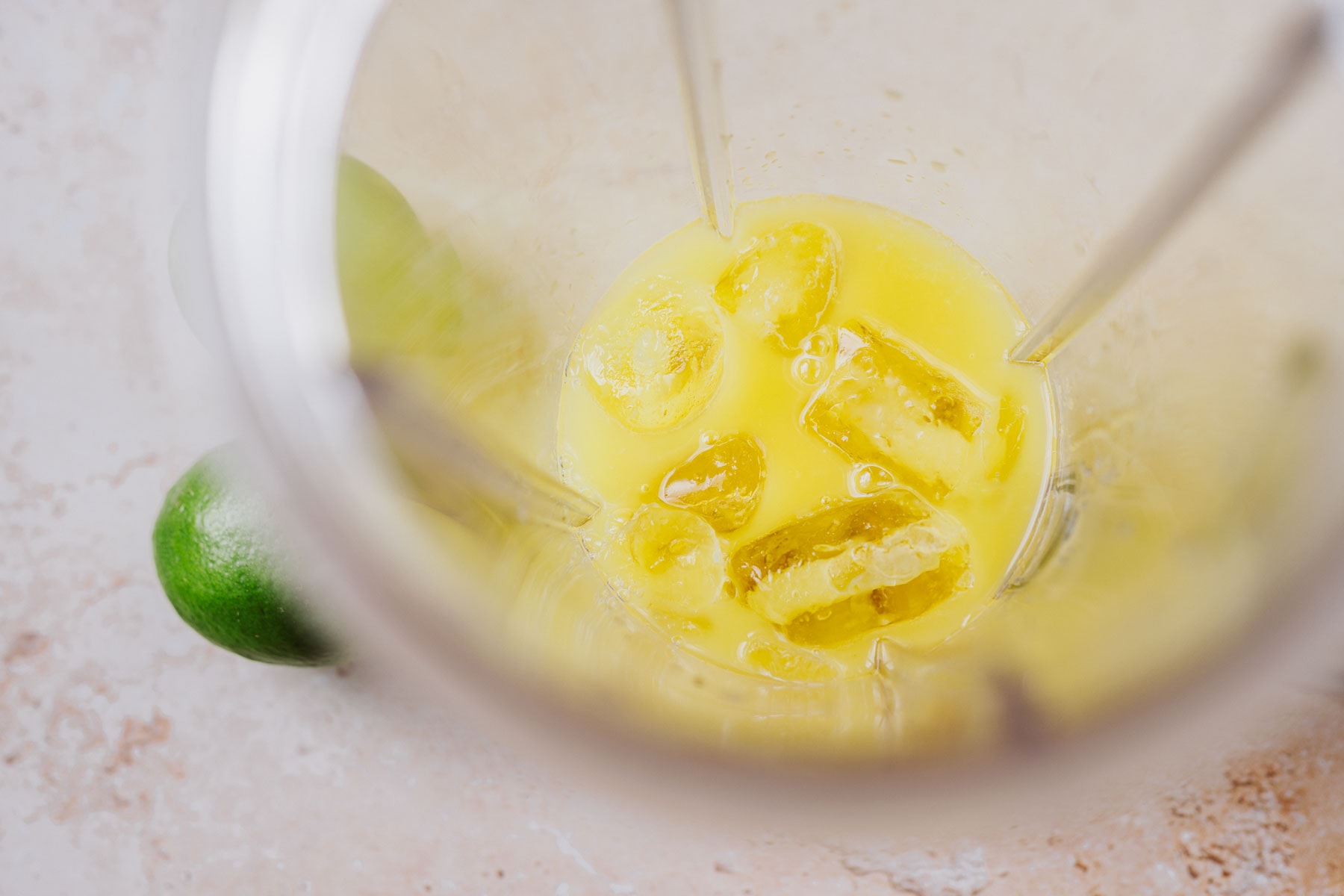 Top view of blender container filled with juice and ice.