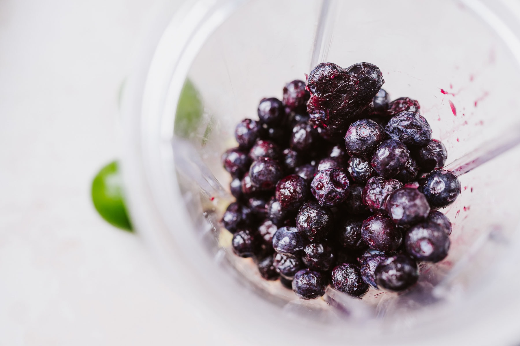 Top view of a blender container filled with blueberries.