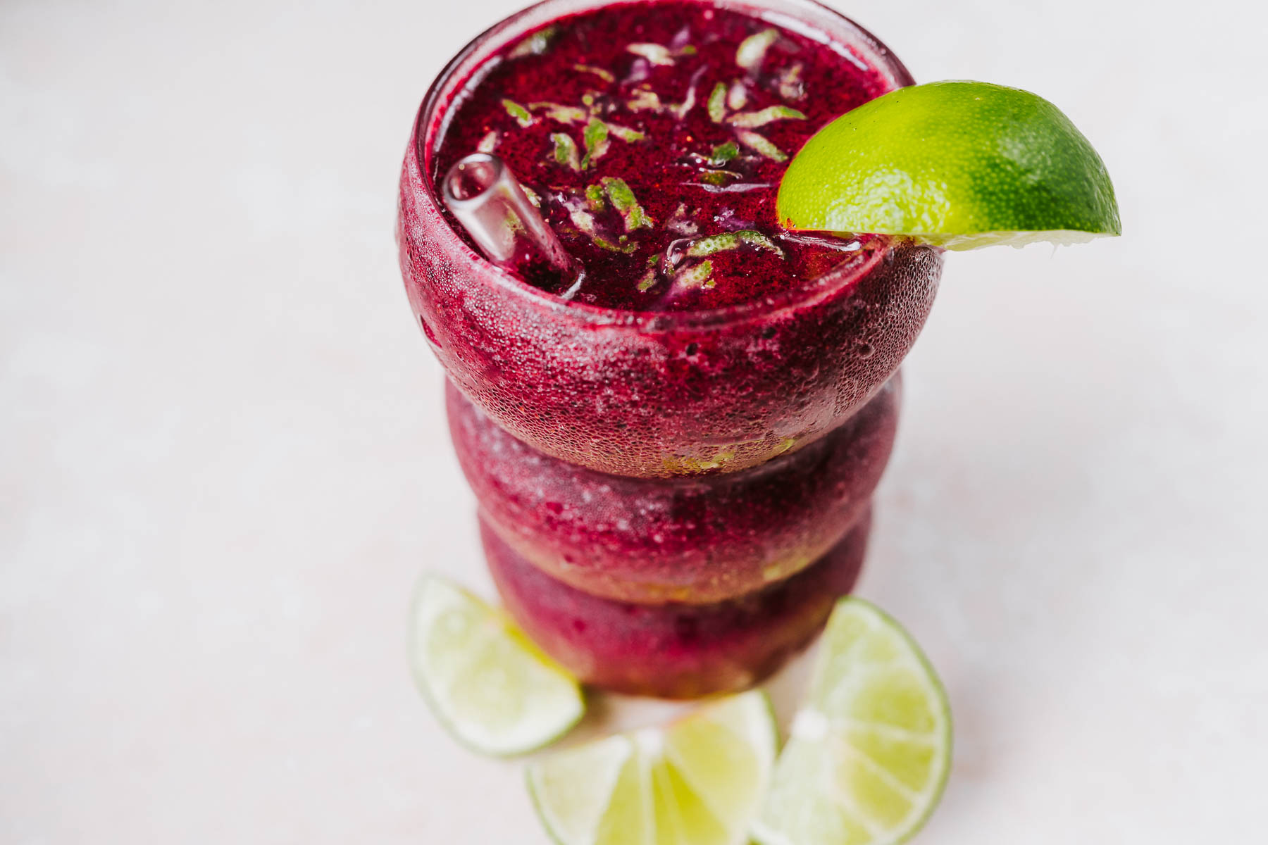 Close view of a clear glass filled with a frozen blueberry margarita mocktail.