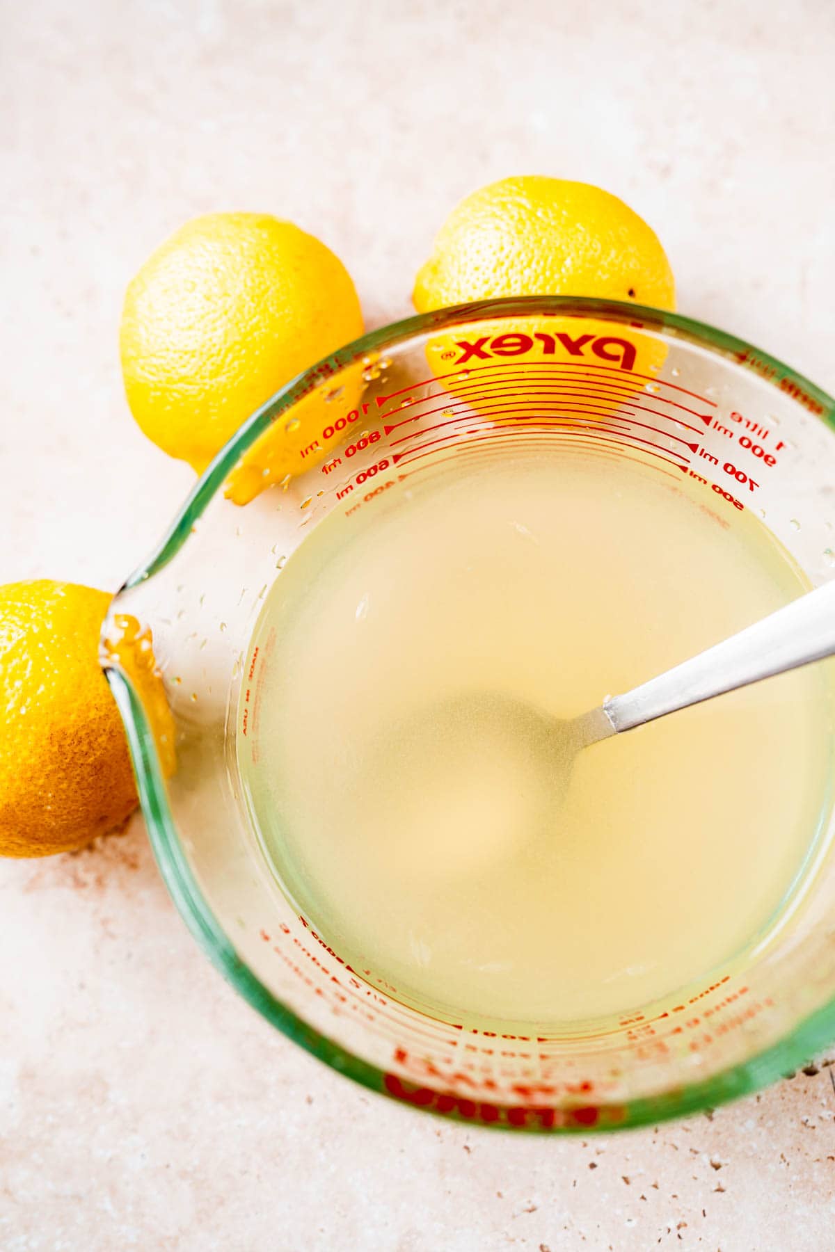 A measuring cup filled with fresh squeezed lemon juice.