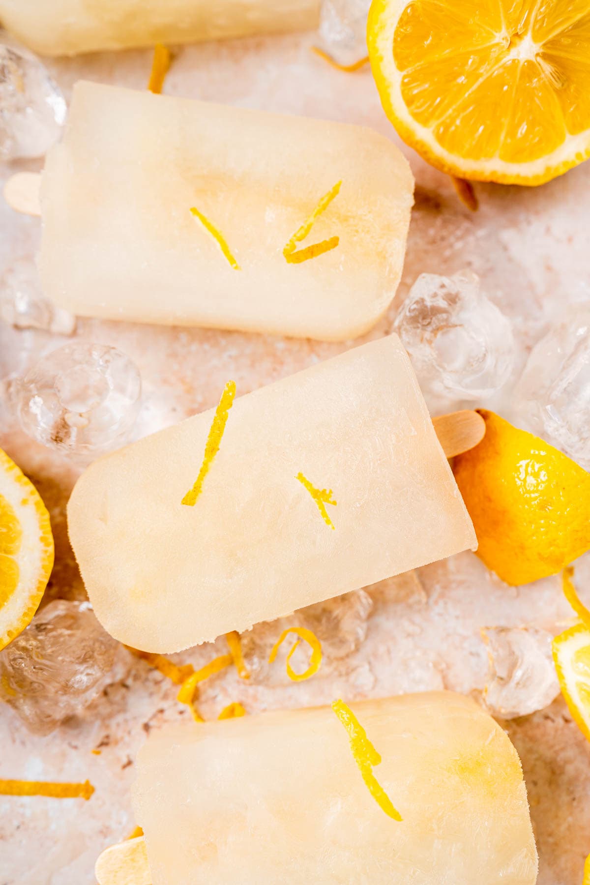 Close shot of homemade lemon ice pops with fresh lemon zest.