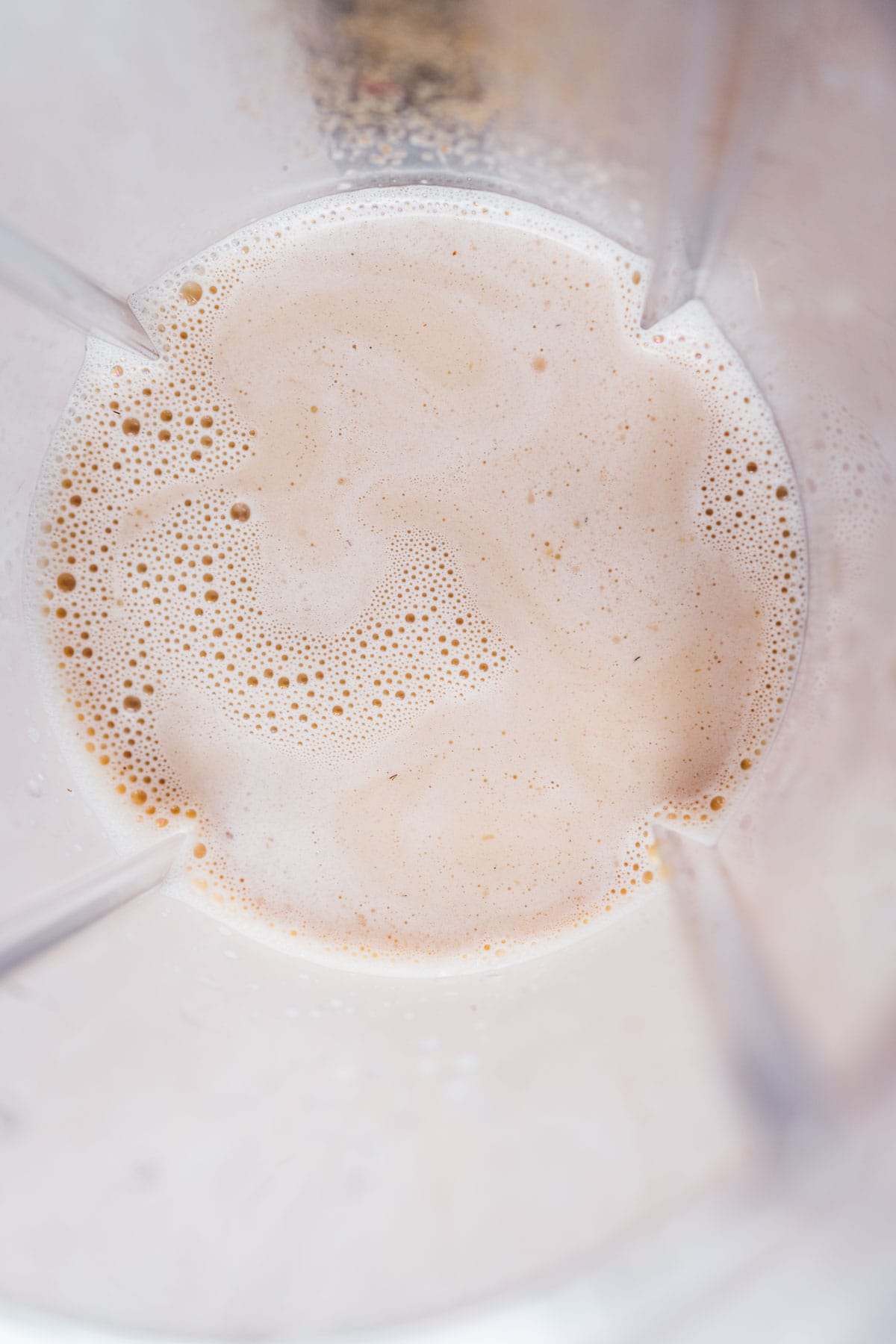 Top view of a blender container filled with milk.