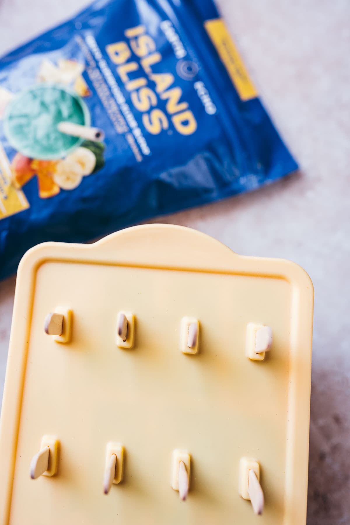 A popsicle mold rests next to a bag of Earth Echo Island Bliss.