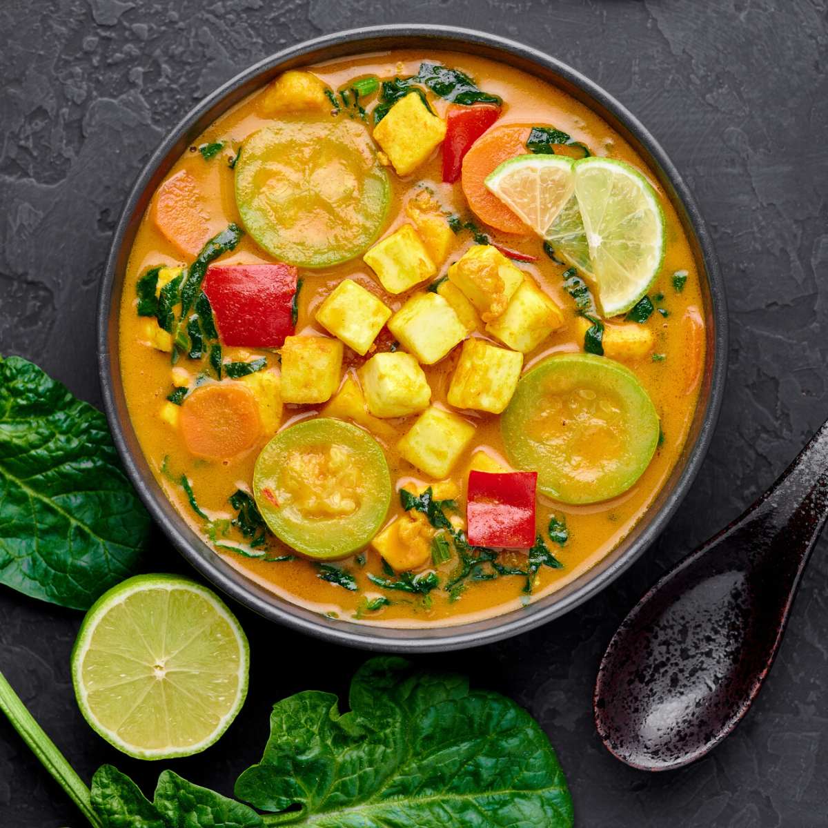 A yellow Thai curry in a large ceramic dish.