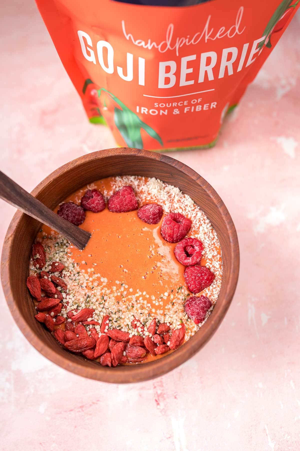 A top view of a goji berry smoothie bowl and a bag of Viva Naturals Goji Berries.