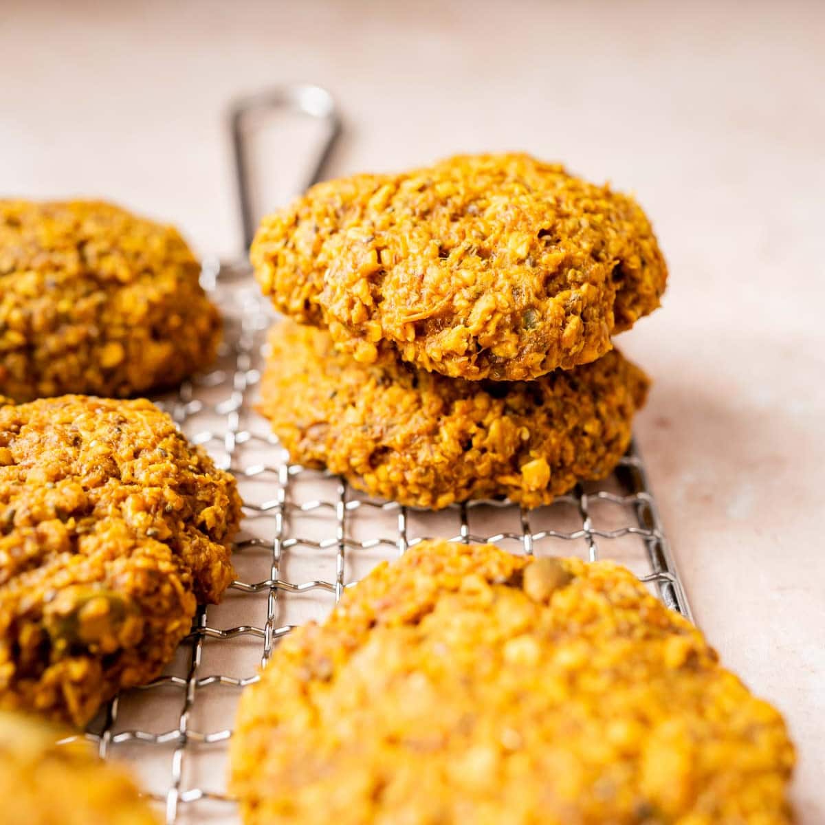 A stack of golden oatmeal cookies on a cooling rack.