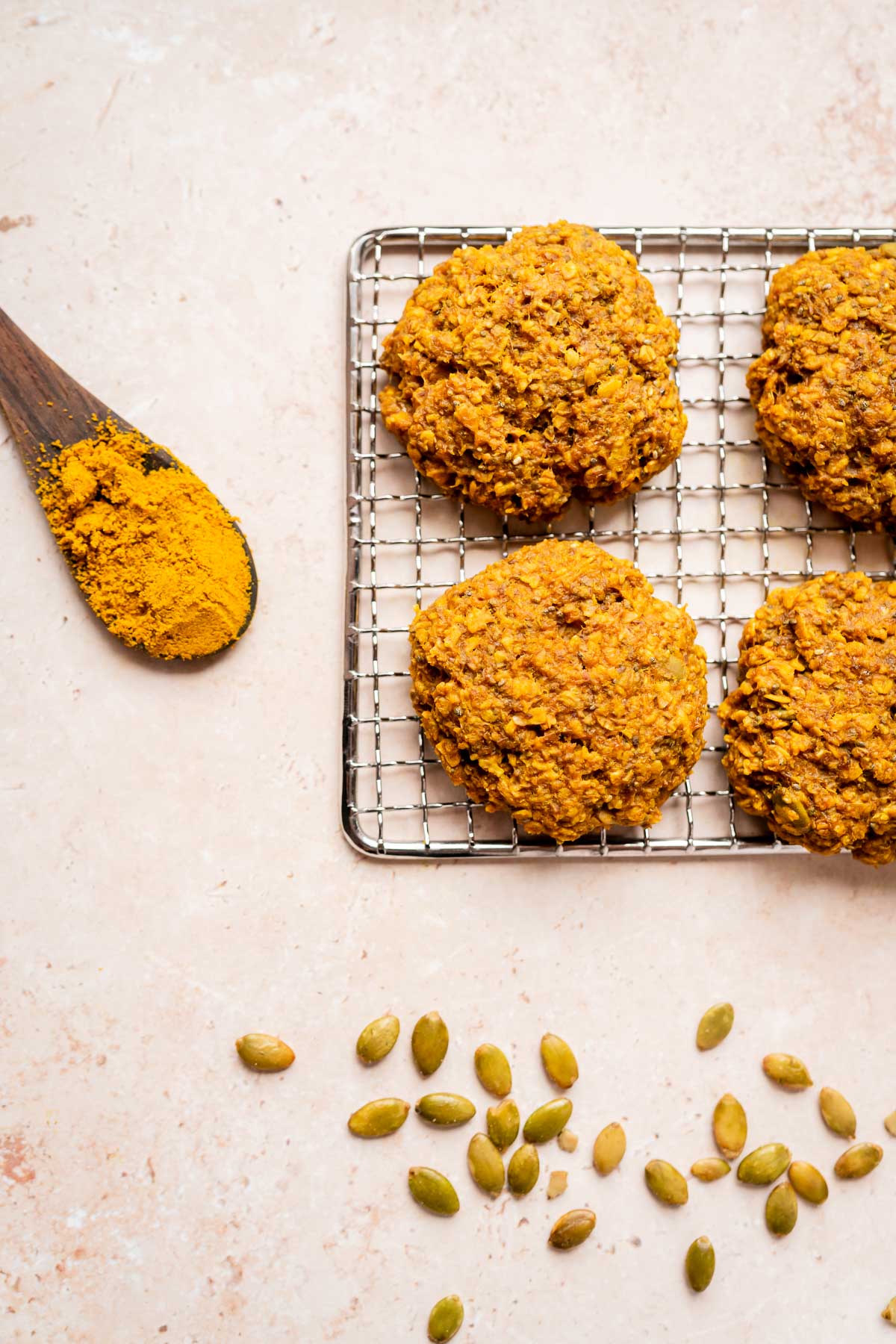 Golden milk cookies on a cooling rack with a spoon.