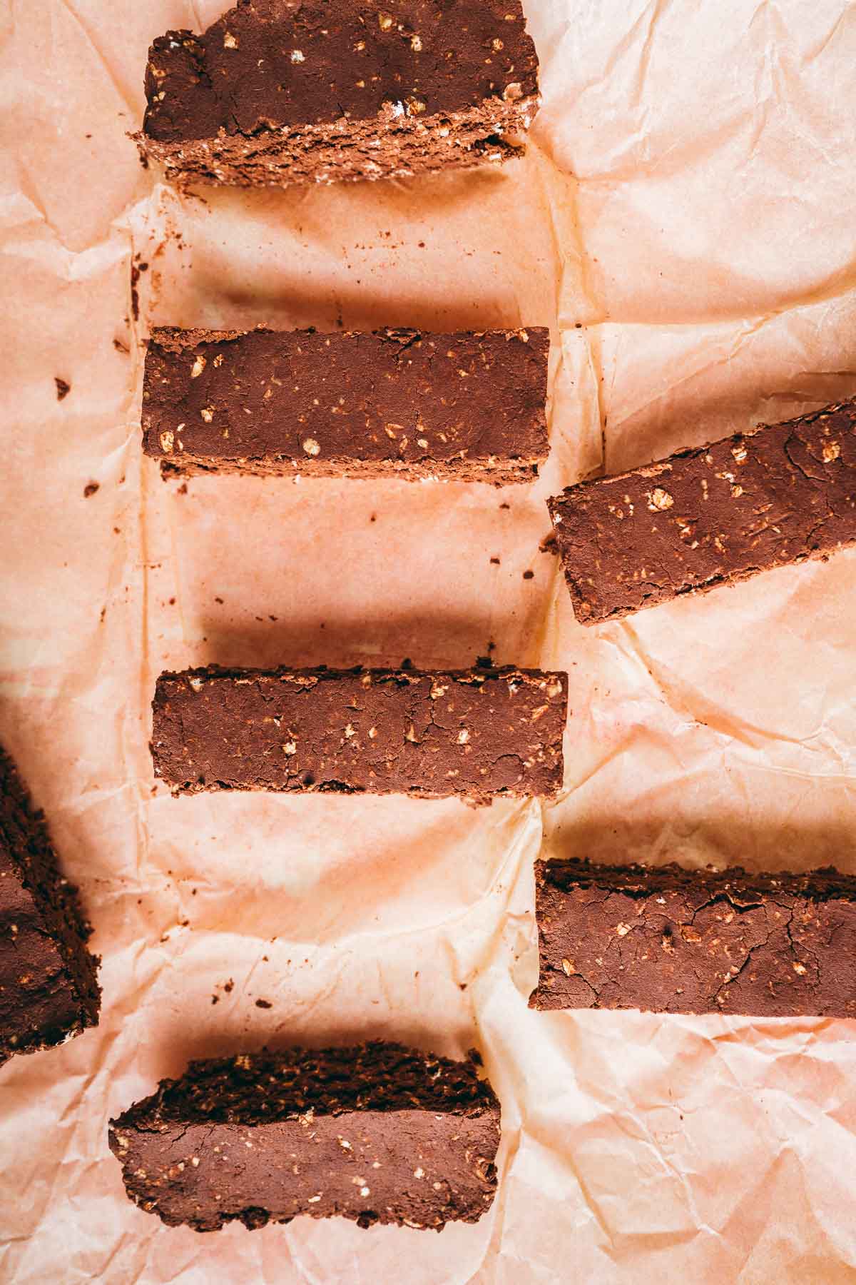 Freshly sliced mocha protein bars resting on a sheet of tan parchment paper.