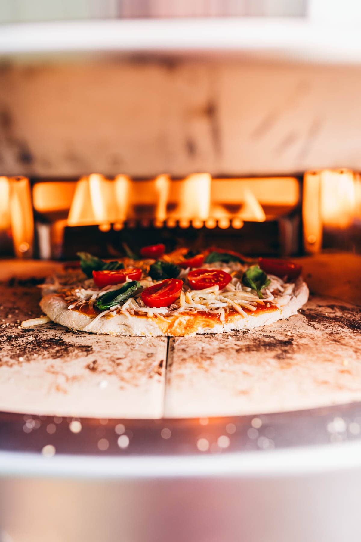 A pizza is being cooked in a Solo Stove pizza oven.