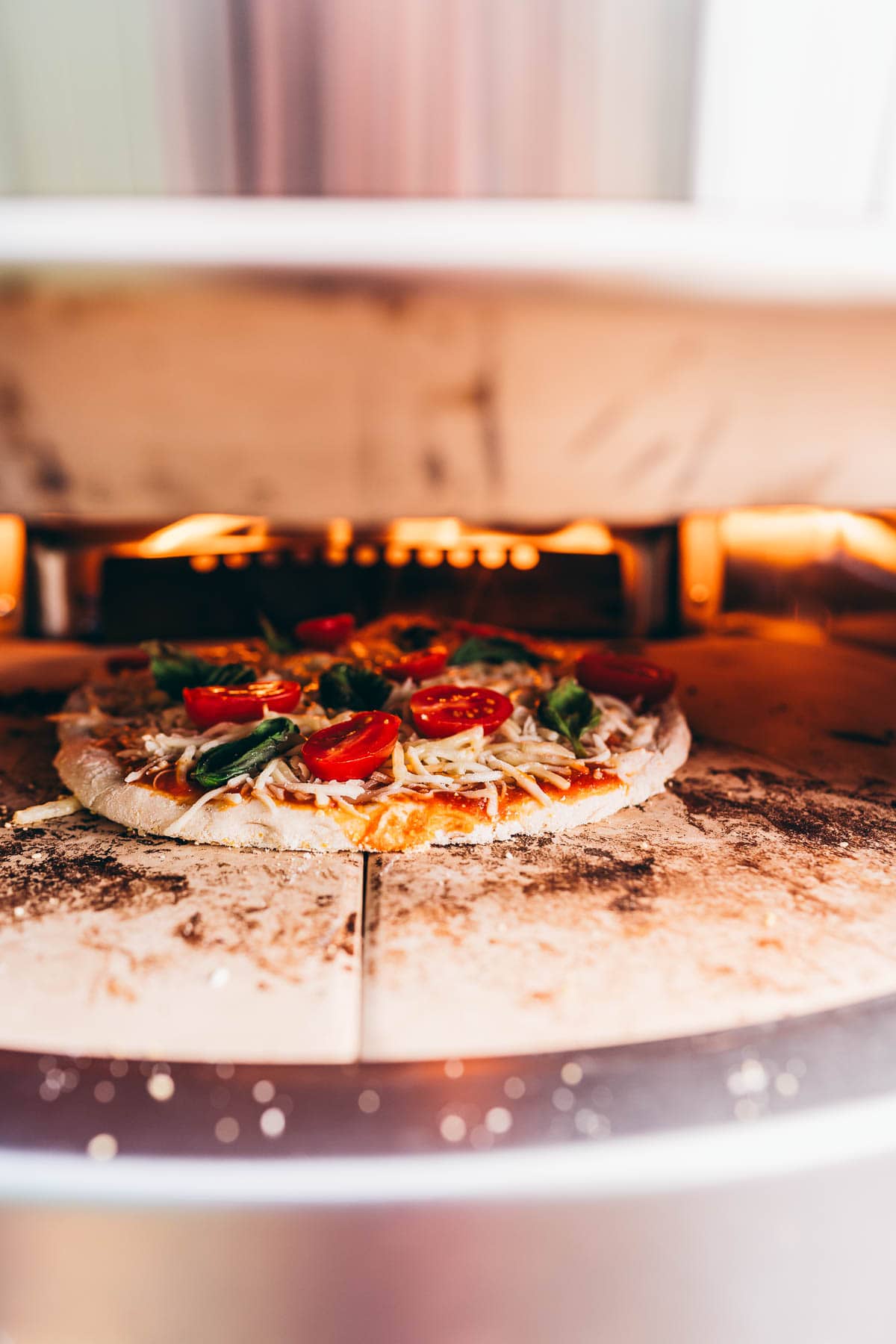 A pizza being cooked in a Solo Stove pizza oven.
