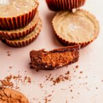 A group of chocolate cups with a bite taken out of it.
