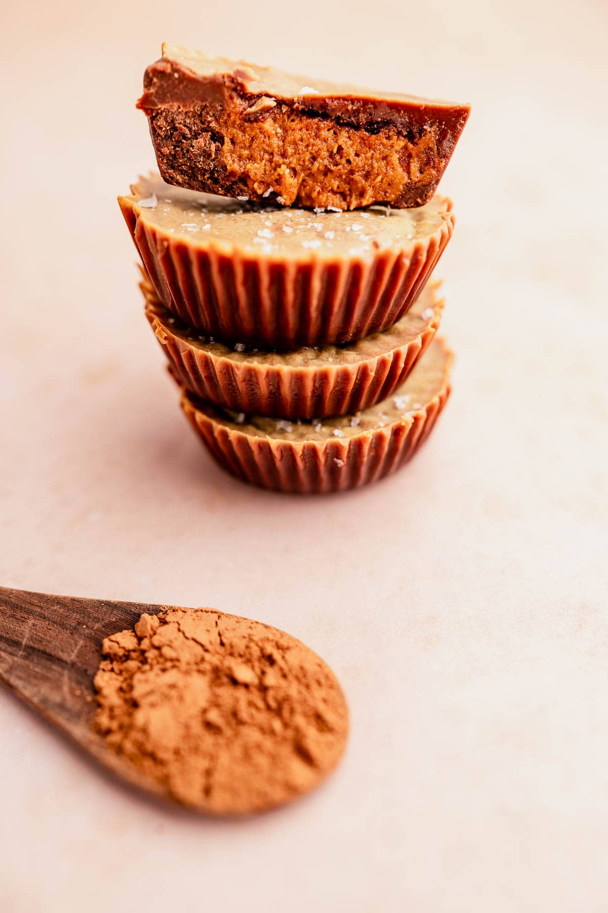 A stack of chocolate almond butter cups with a spoon in the middle.