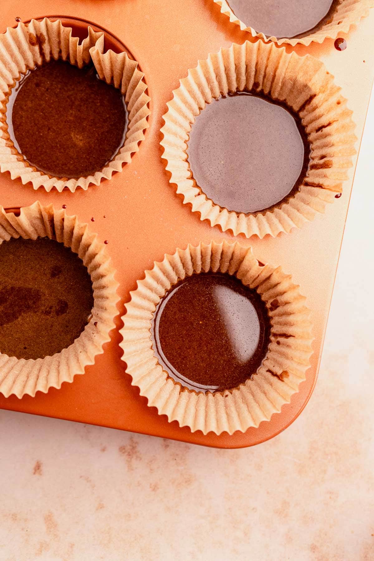 Chocolate pumpkin cupcakes in a muffin tin.
