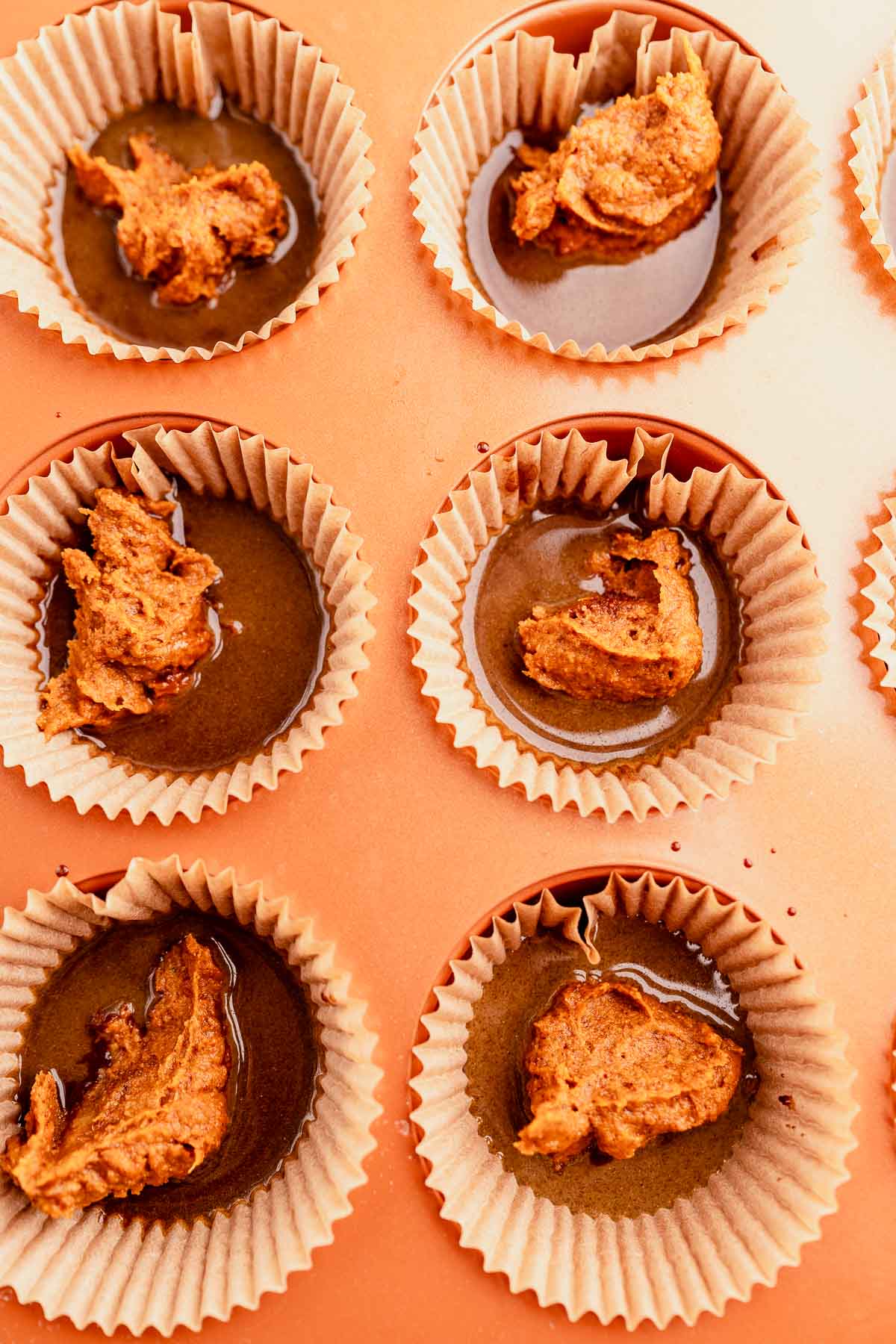 Peanut butter cupcakes in a muffin tin with chocolate almond butter cups.