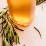 A bottle of rosemary simple syrup on a white background.