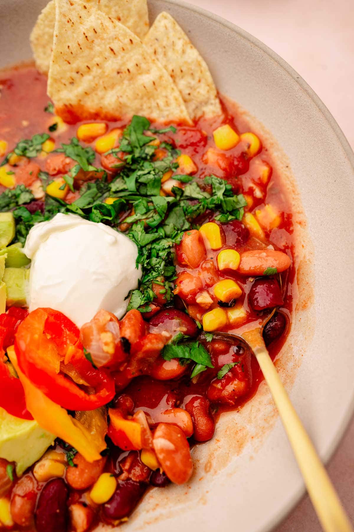 A hearty bowl of slow cooker vegetarian chili with a touch of sour cream and guacamole.