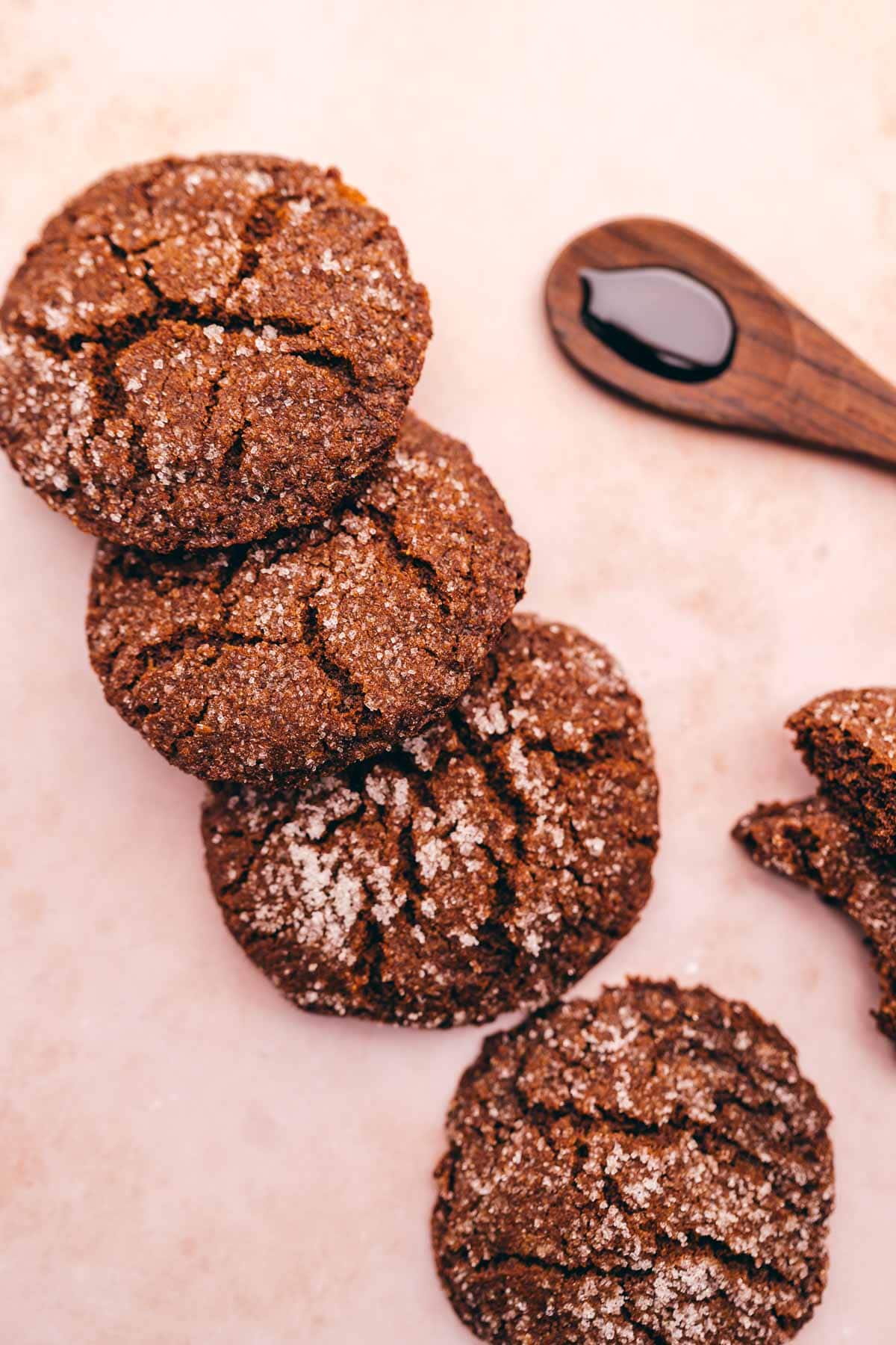A group of gluten free ginger molasses cookies with a spoon on a table.