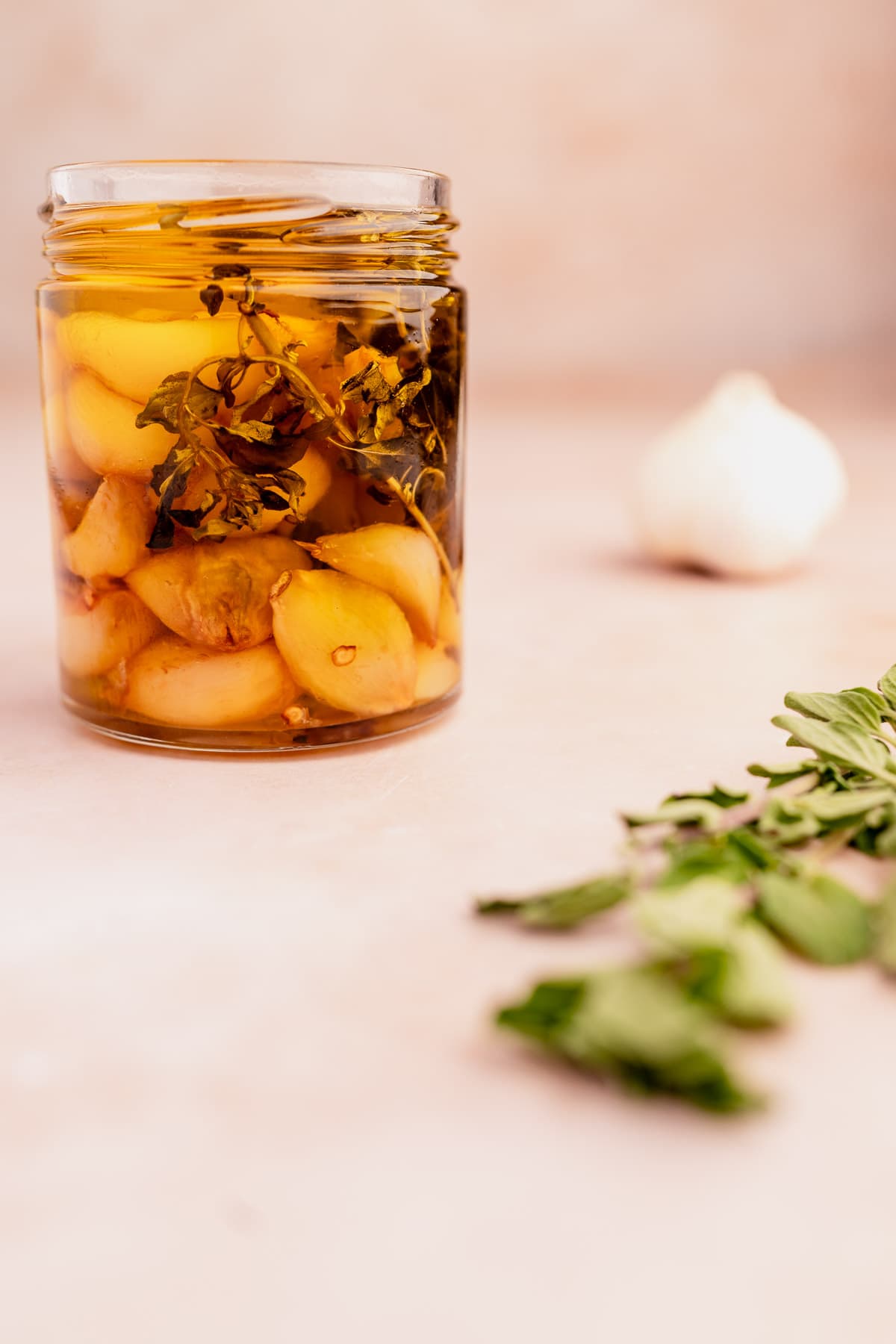 A jar of pickled garlic confit on a table.