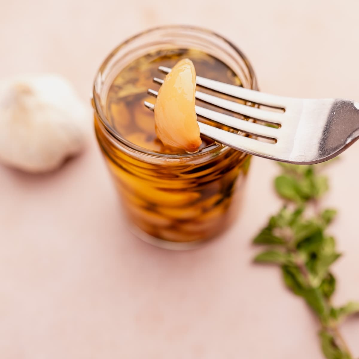 A jar of garlic confit submerged in fragrant olive oil.