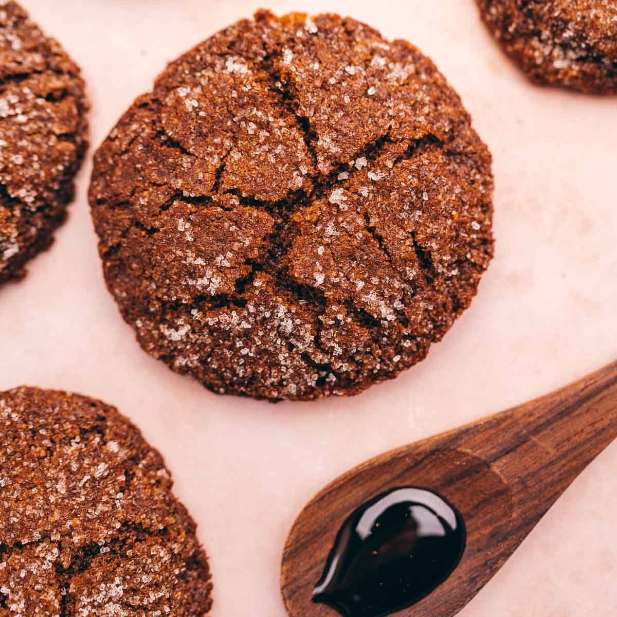 Gluten-free gingerbread cookies with a spoon on a pink background.