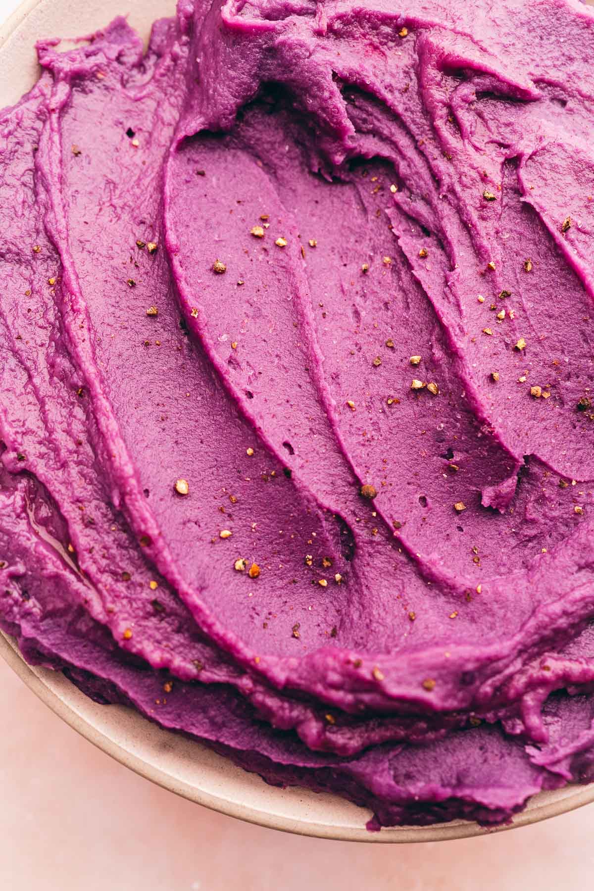 Mashed purple sweet potatoes ice cream in a bowl with gold sprinkles.