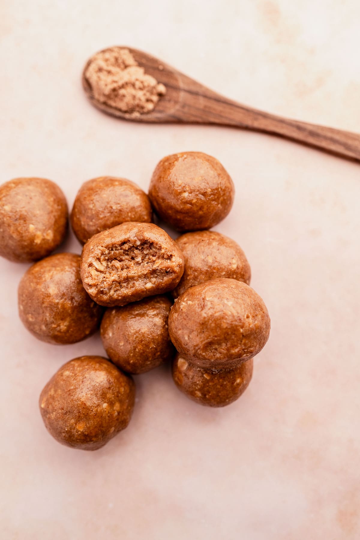 Chai energy bites on a table with a wooden spoon.