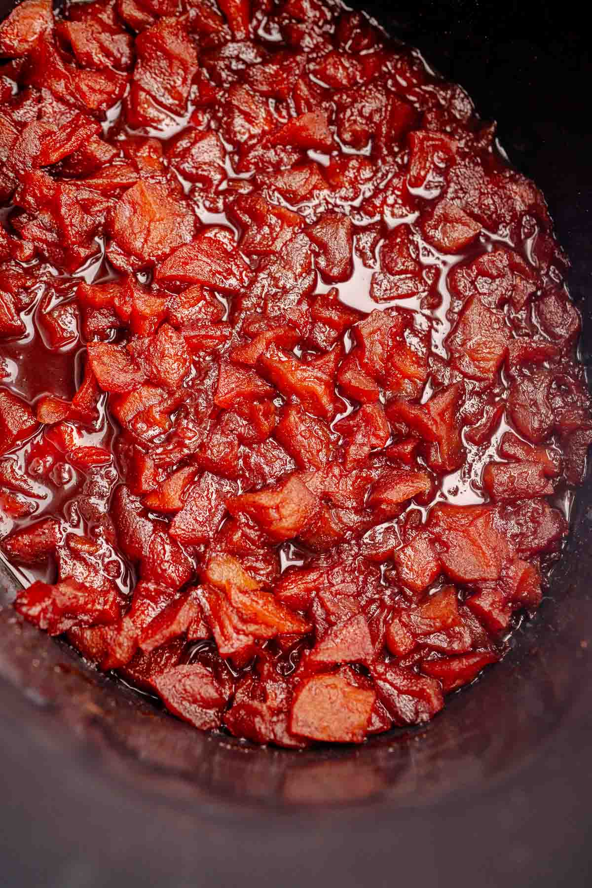 A slow cooker filled with cranberry sauce and apple butter.