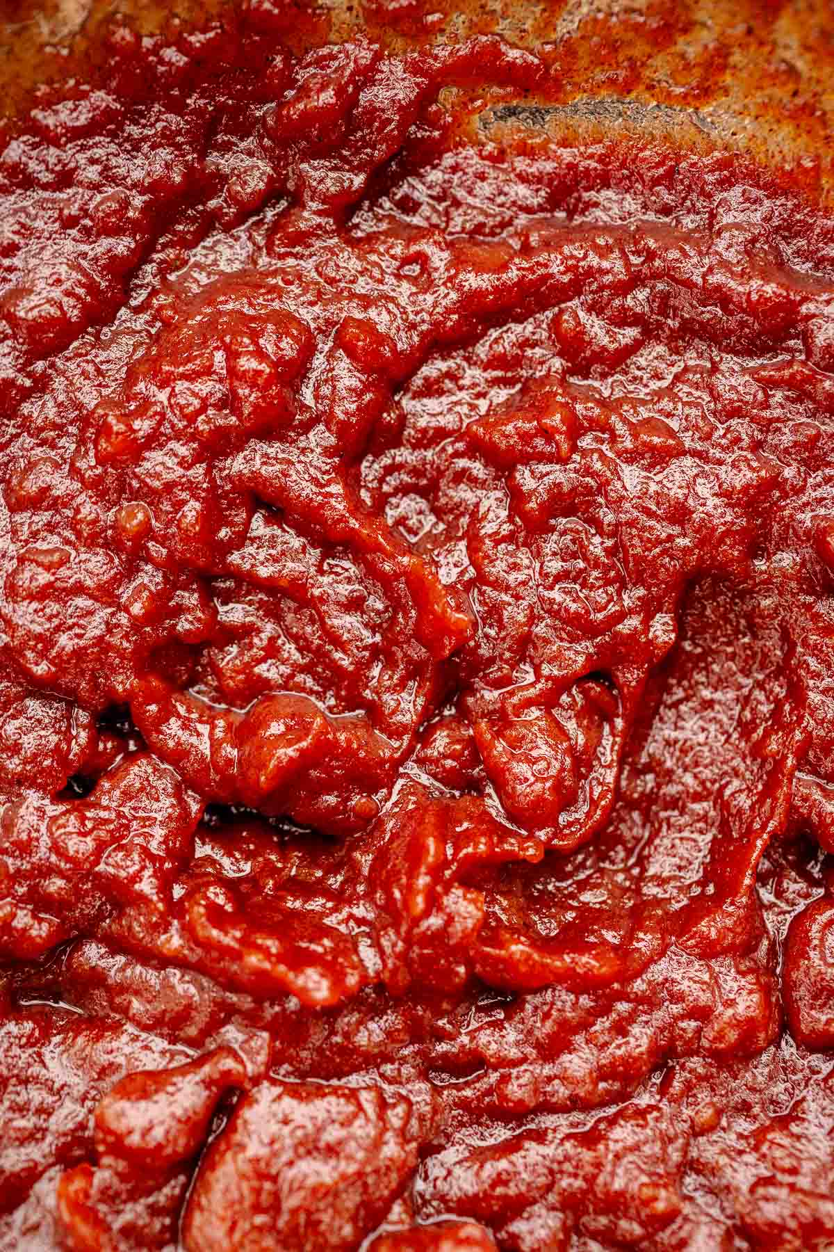 A close up of a red sauce simmering in a pan.